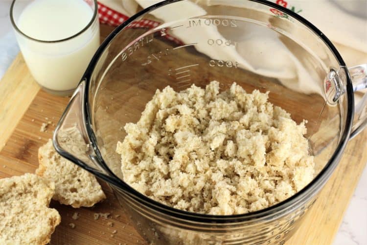 breadcrumbs in a large measuring cup with glass of milk on side
