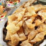 chiacchiere di carnevale piled onto silver tray