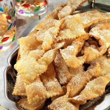 chiacchiere di carnevale piled onto silver tray