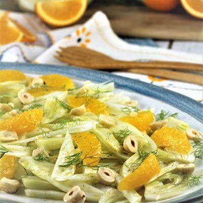 blue rimmed white platter with sliced fennel, orange segments and hazelnuts