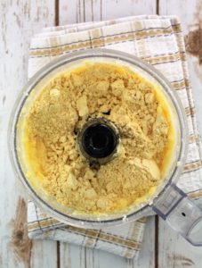 chickpea flour added to butter mixture in bowl of food processor