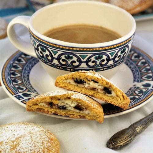 blue and white coffee cup with sweet panelle cookie cut in half on the saucer