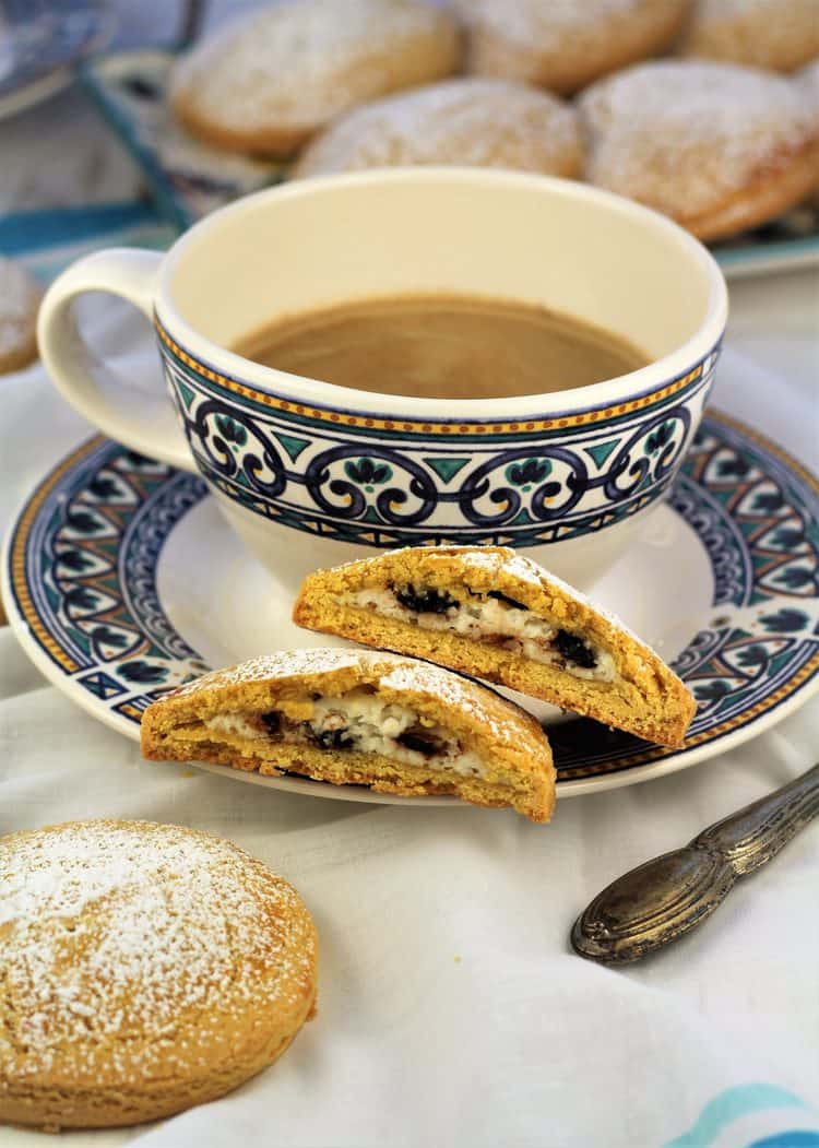 coffee cup with sweet panelle cookie cut in half resting on saucer