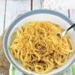 blue rimmed bowl of spaghetti with breadcrumbs with fork in it