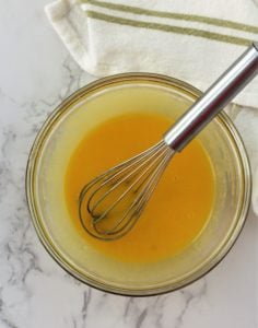 whisk in glass bowl with eggs and sugar 