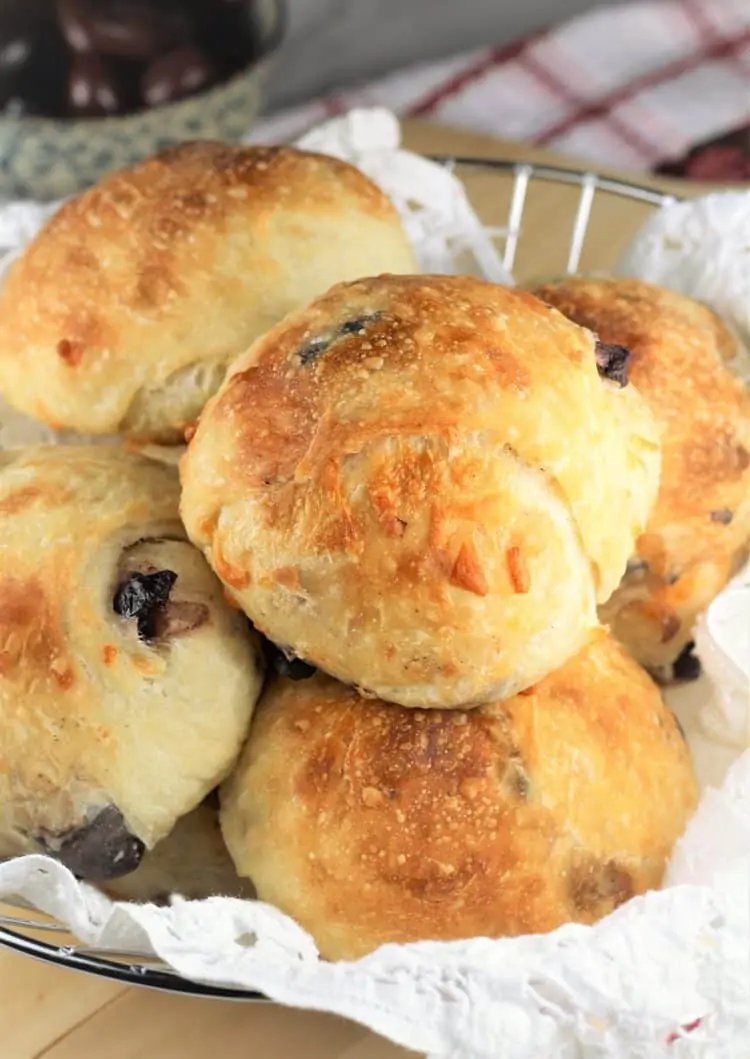 olive and cheese buns in breadbasket with bowl of olives in background