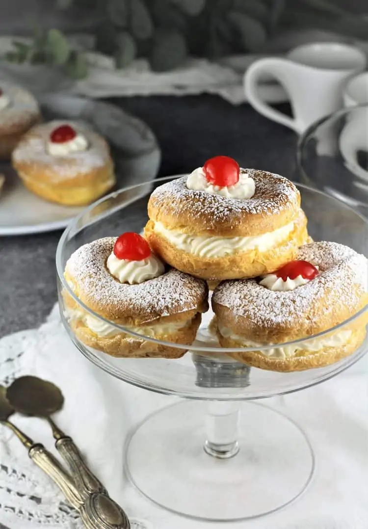 glass pedestal plate with 3 zeppole filled with ricotta for St-Joseph's Day with cherry tops 