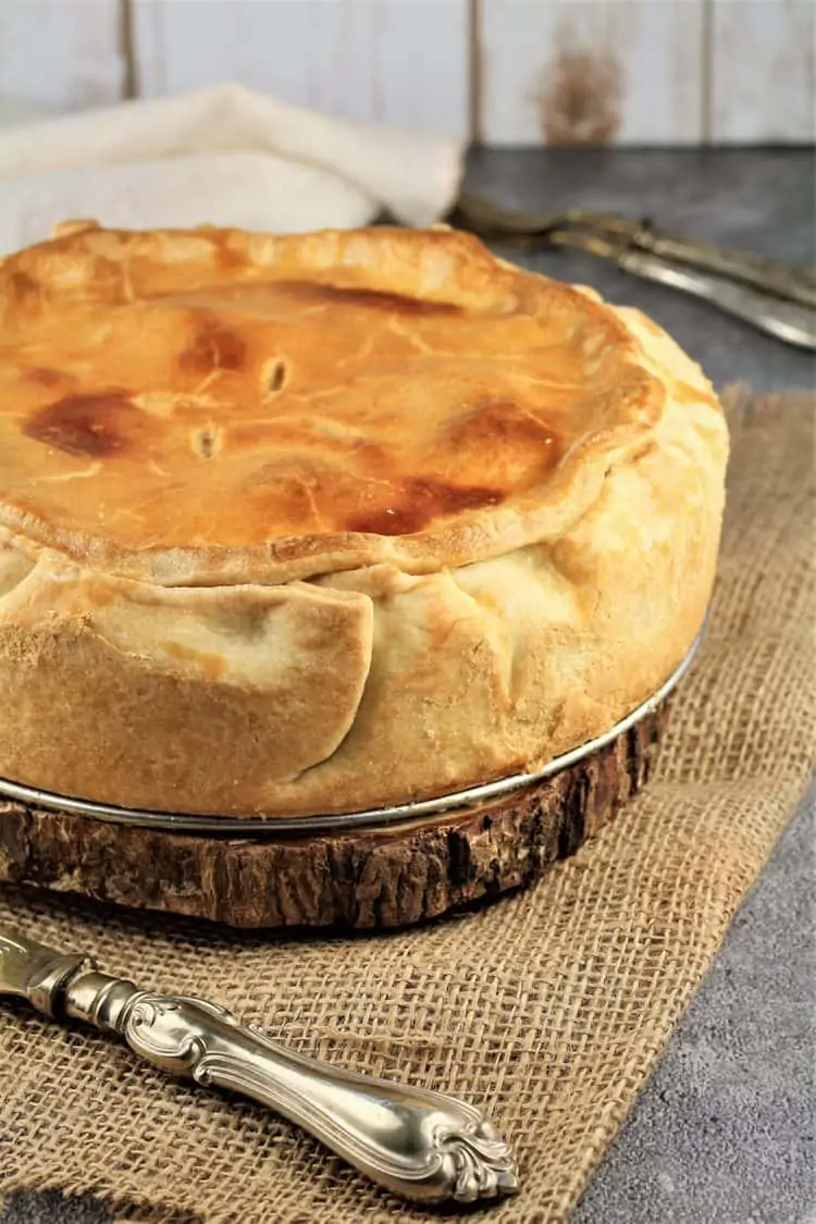 Easter pie on tree trunk pot holder over burlap cloth with silver knife