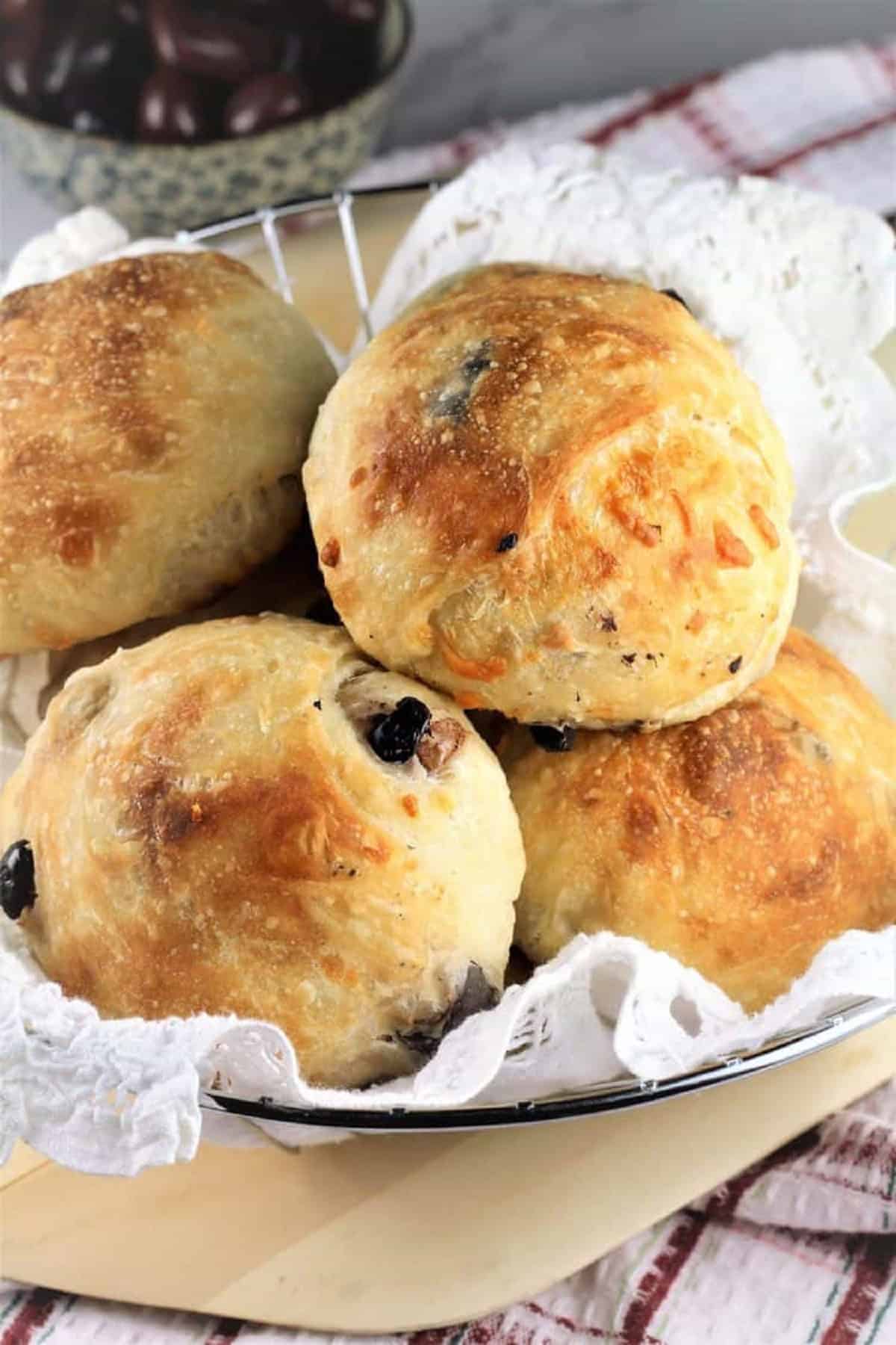 Italian olive and cheese stuffed buns piled in basket.