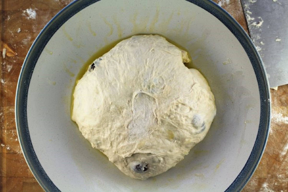 No knead olive and cheese rolls dough shaped into a ball in greased bowl.
