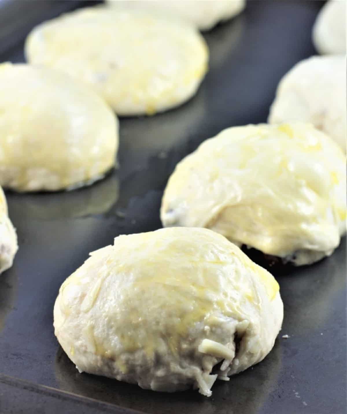 No knead olive and cheese buns on baking sheet.