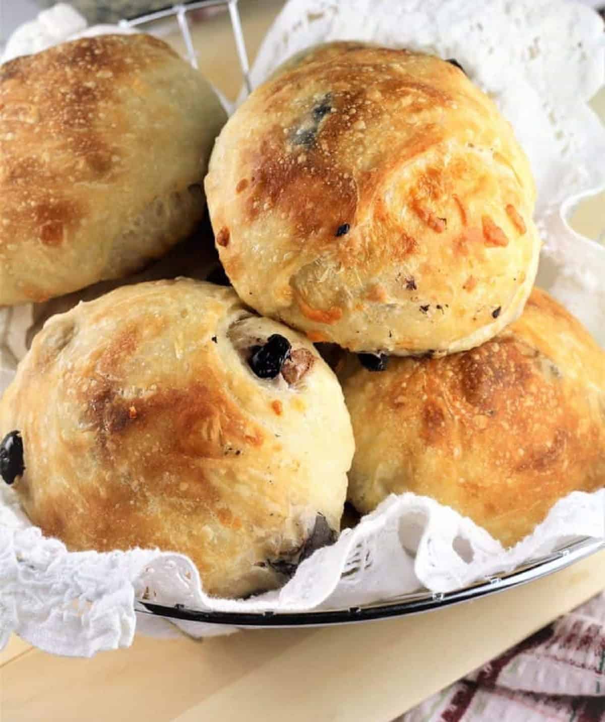 No knead olive and cheeese buns in wire basket.