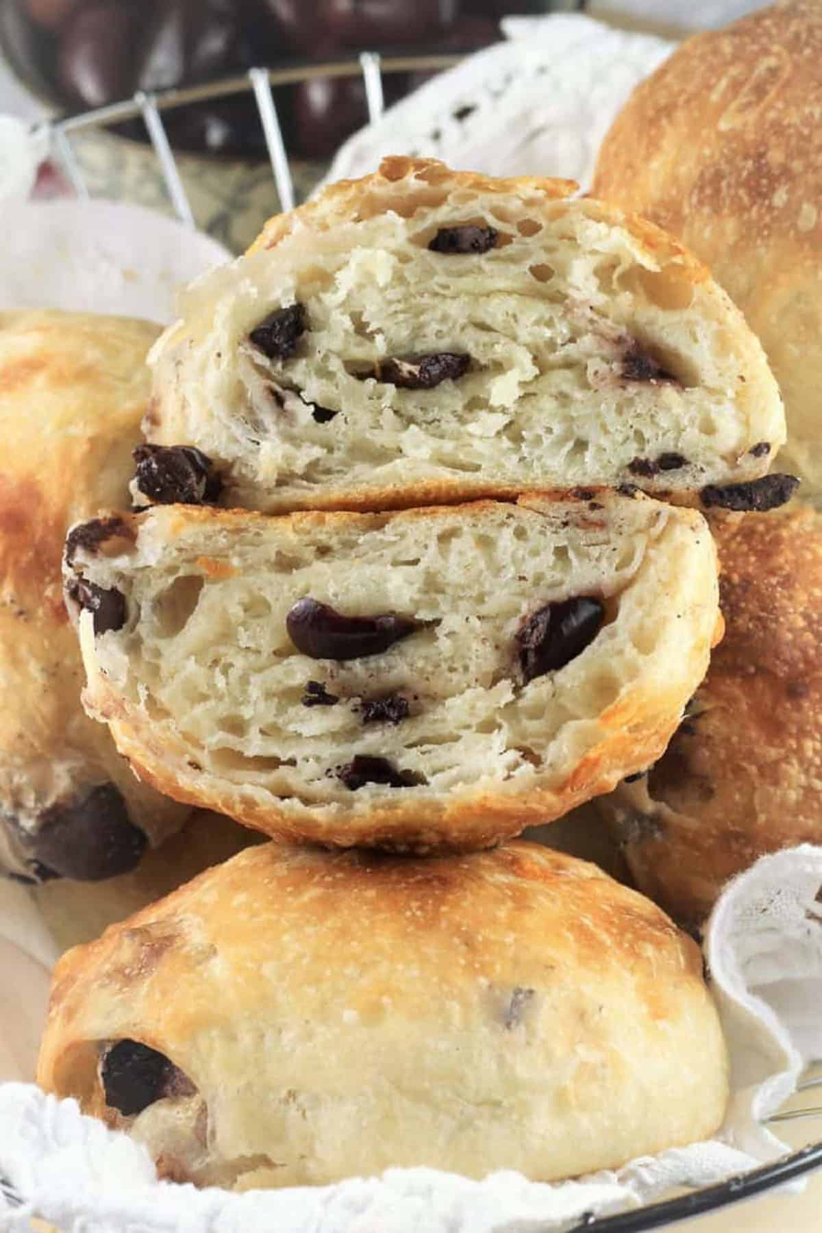Stuffed rolls with olives and cheese cut open in wire basket.