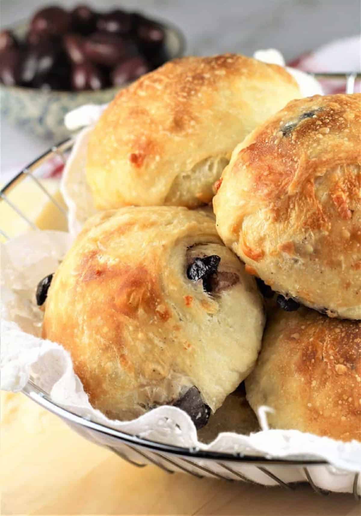 Italian rolls stuffed with cheese and olives piled in basket.