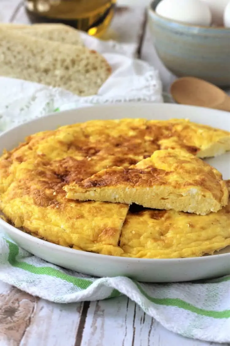 wedges of frittata in white plate with bread in background