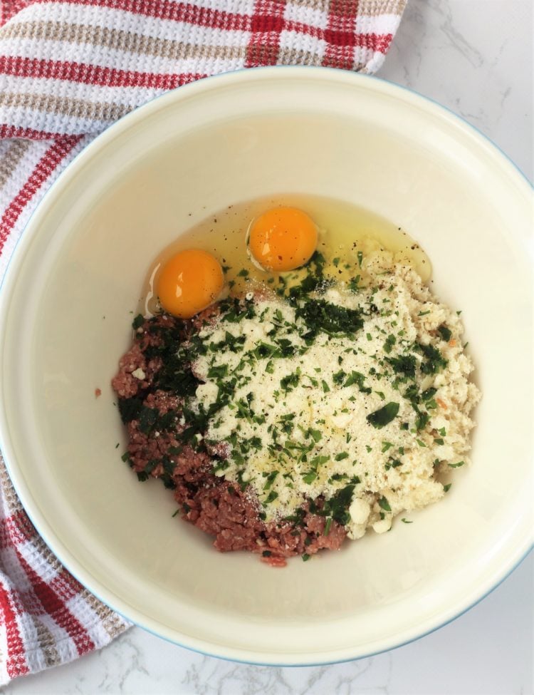 bowl with groud meat, breadcrumbs, eggs and cheese for meatballs