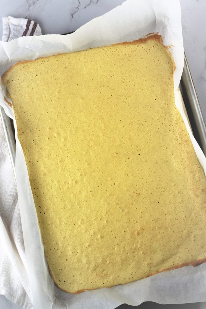 baked sponge roll cake on baking sheet 