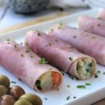 prosciutto cotto rolled with russian salad on white platter
