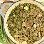 large skillet with fava bean and pea stew