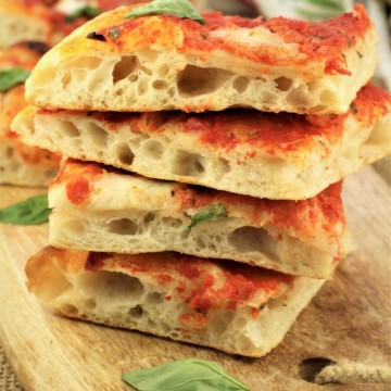 wedges of tomato topped pizza piled on one another