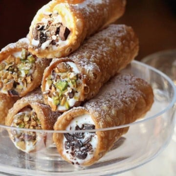 cannoli with ricotta piled on glass plate