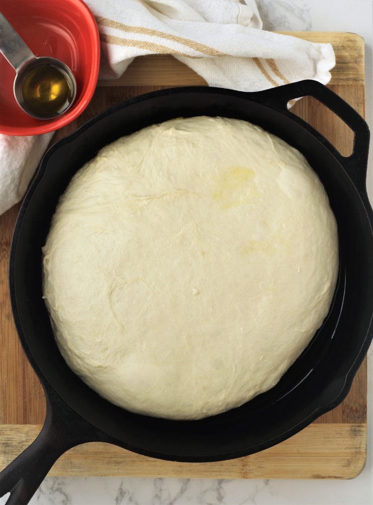 cast iron skillet with focaccia dough in it