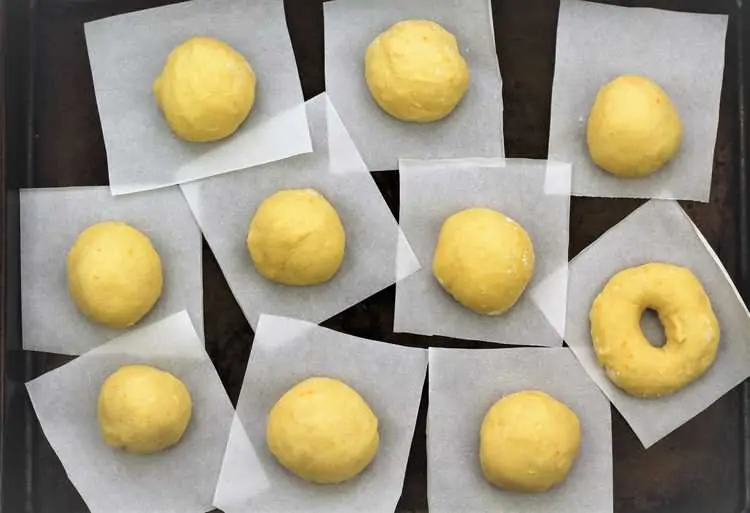balls of dough on parchment paper squares