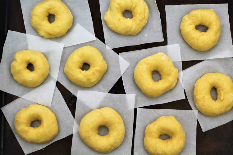 round shaped doughnut dough on parchment paper squares 