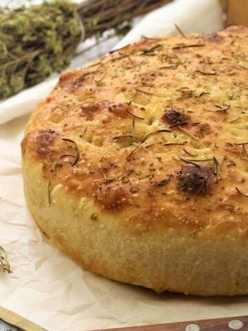 No knead cast iron focaccia bread topped with herbs.