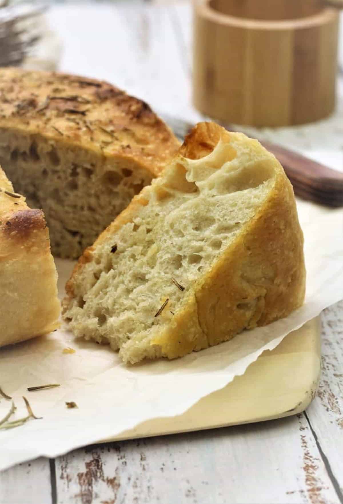 Wedge of cast iron focaccia bread on wood board.