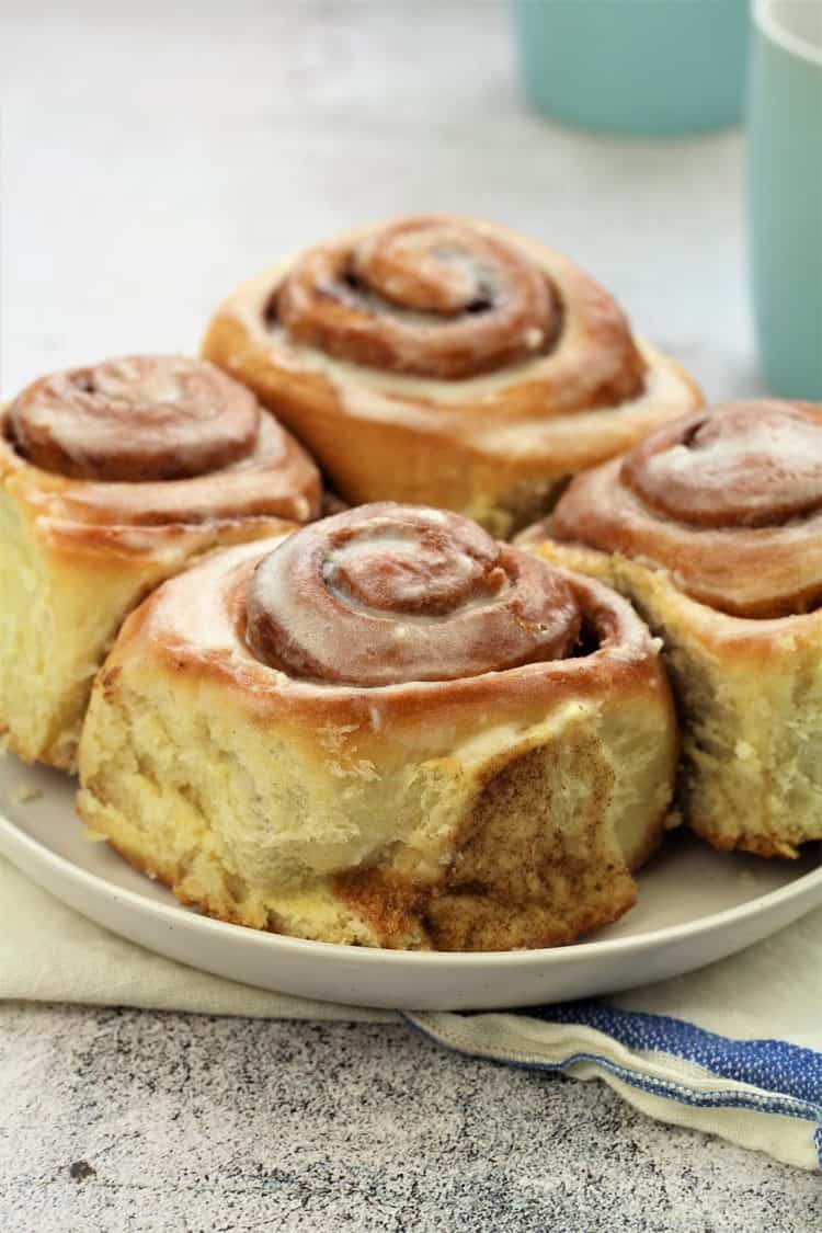 4 cinnamon rolls on white round plate