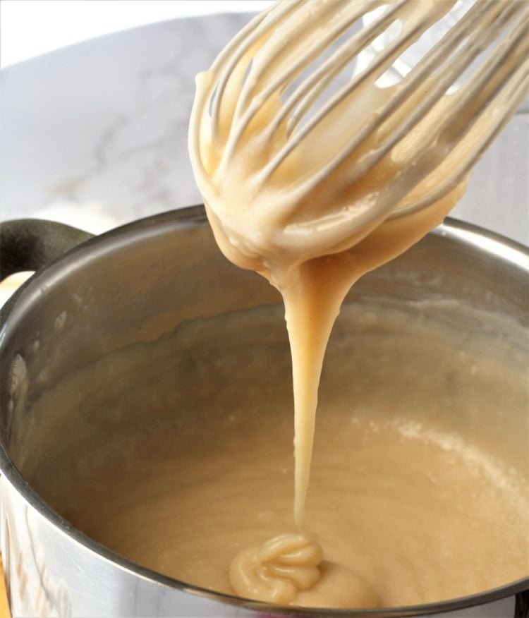 whisk over sauce pan with pudding dripping into the pan