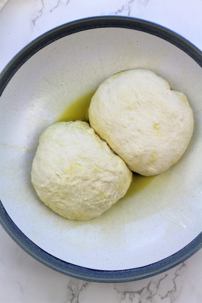 2 balls of dough in greased bowl 