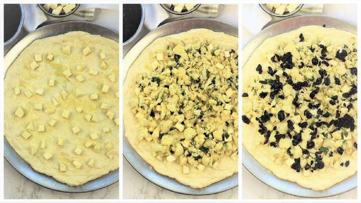 Toppings for cauliflower and black olive scacciata spread over dough.