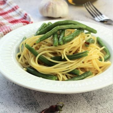 white bowl filled with spaghetti with green beans
