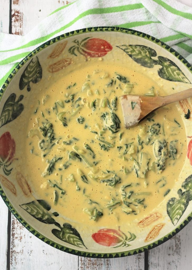 swiss chard stirred into batter in large bowl with wood spoon