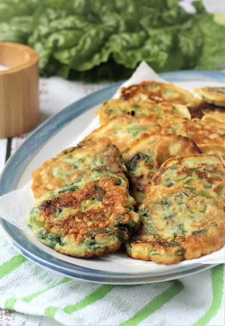 swiss chard fritters layered in blue rimmed platter