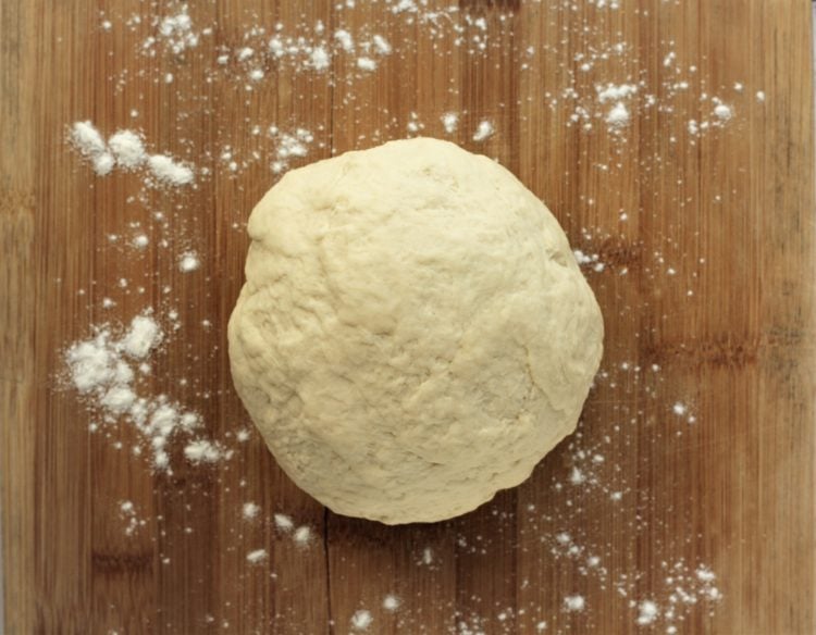 ball of kneaded pizza dough on wood board Sfincione Siciliano (Sicilian Style Pizza)