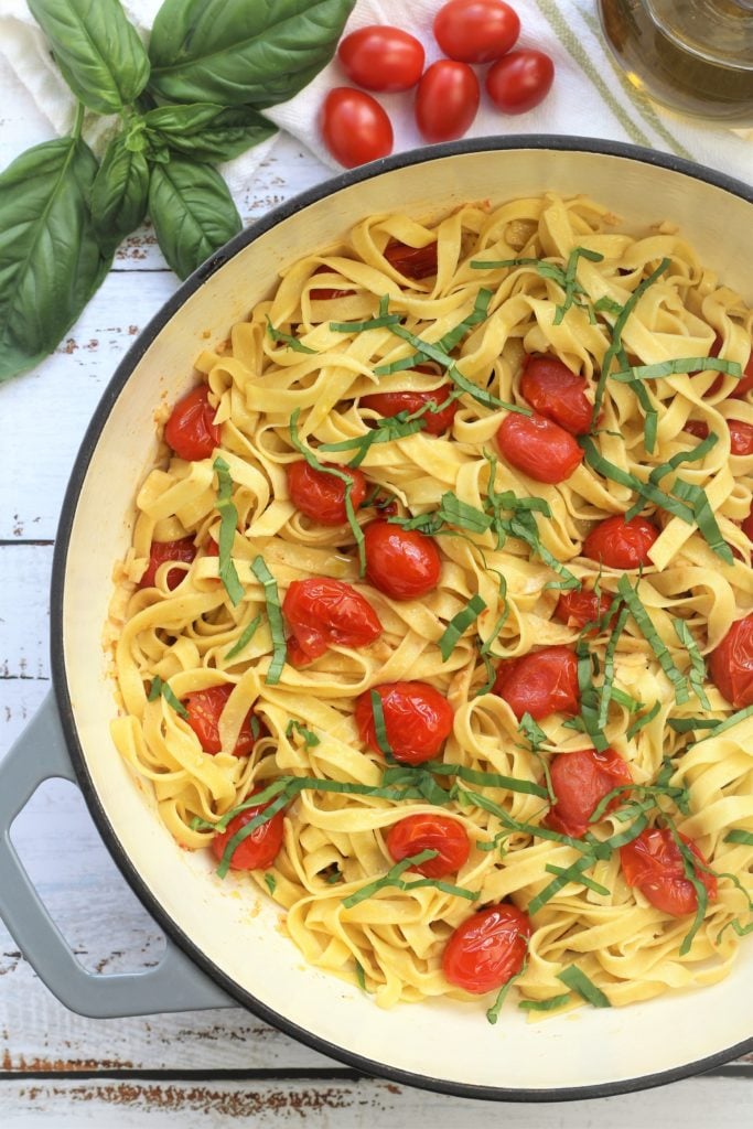 skillet filled with homemade tagliatelle with cherry tomatoes, garlic and basil 