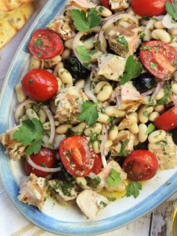 Grilled tuna and white bean salad with crostini on side.