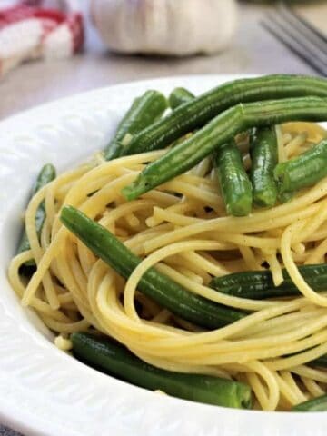 Spaghetti with green beans in bowl.