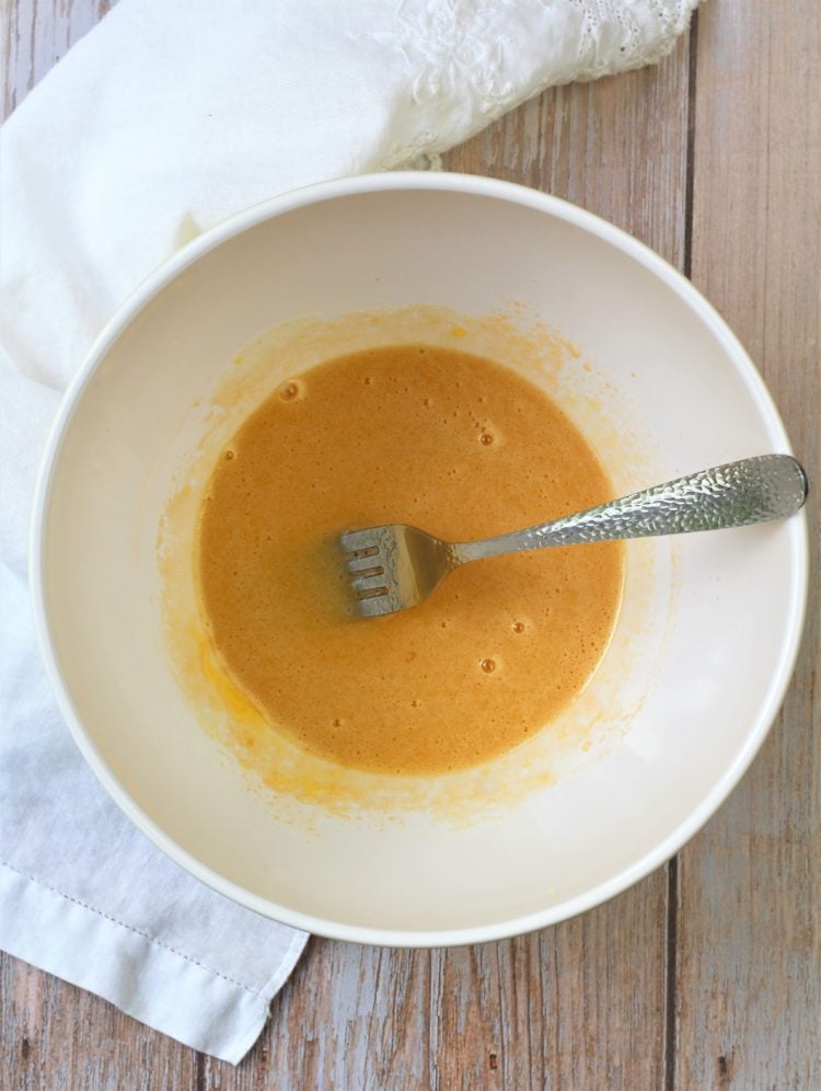 beaten egg and sugar with fork in white bowl