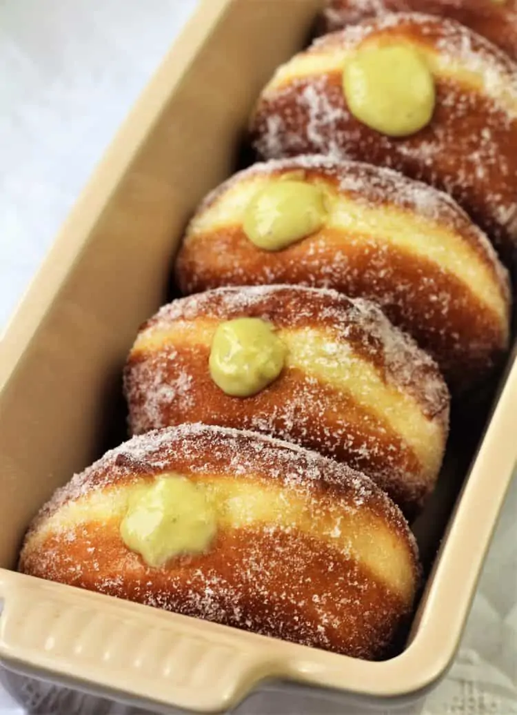 pistachio custard filled sugar doughnuts stacked in loaf pan