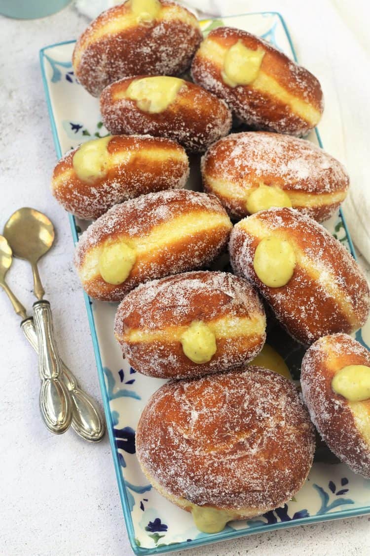 pistachio cream filled sugar doughnuts on rectangular serving plate