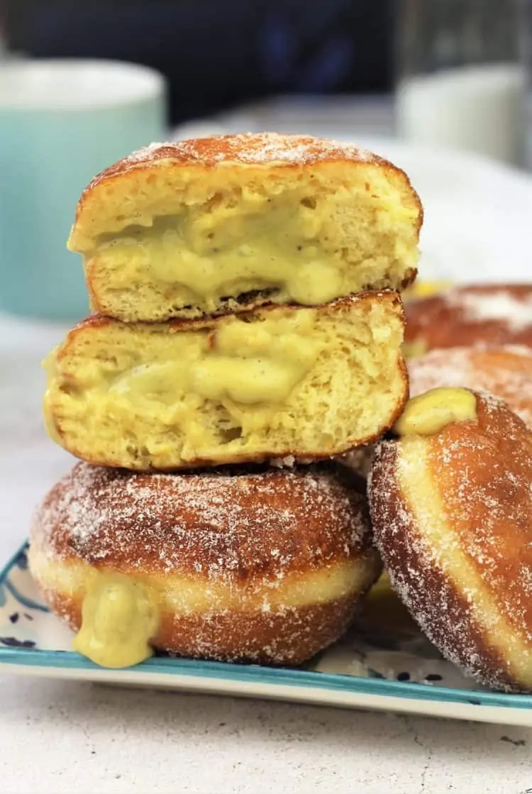 pistachio custard filled bomboloni cut open piled on doughnuts 