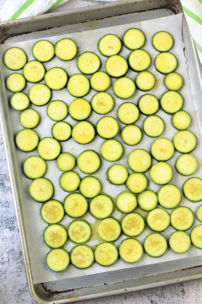 zucchini cut into rounds on parchment paper covered baking sheet 