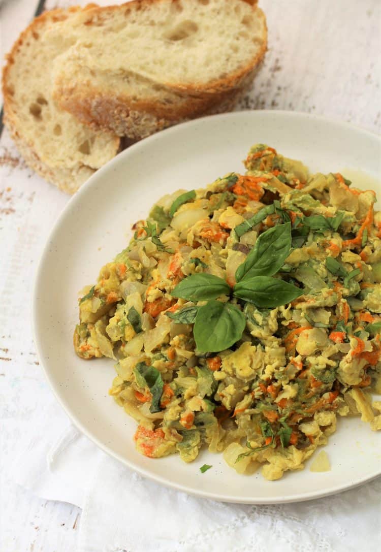 white round plate with zucchini blossom and egg scramble with sliced bread 