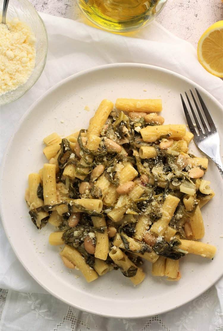 white round plate with pasta, swiss chard and white beans