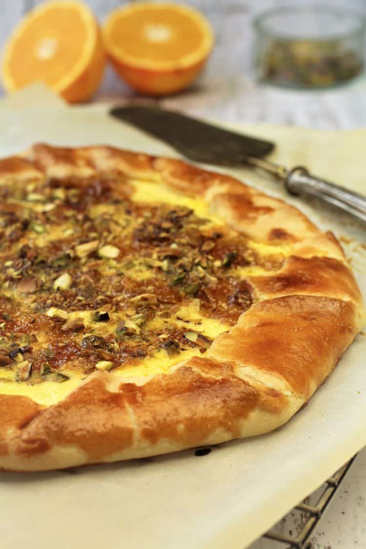 Fig Jam, Ricotta and Pistachio Crostata on parchment paper covered wire rack