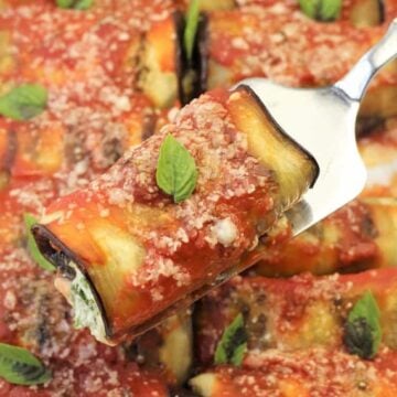 Eggplant rolls with spinach ricotta filling on fork.